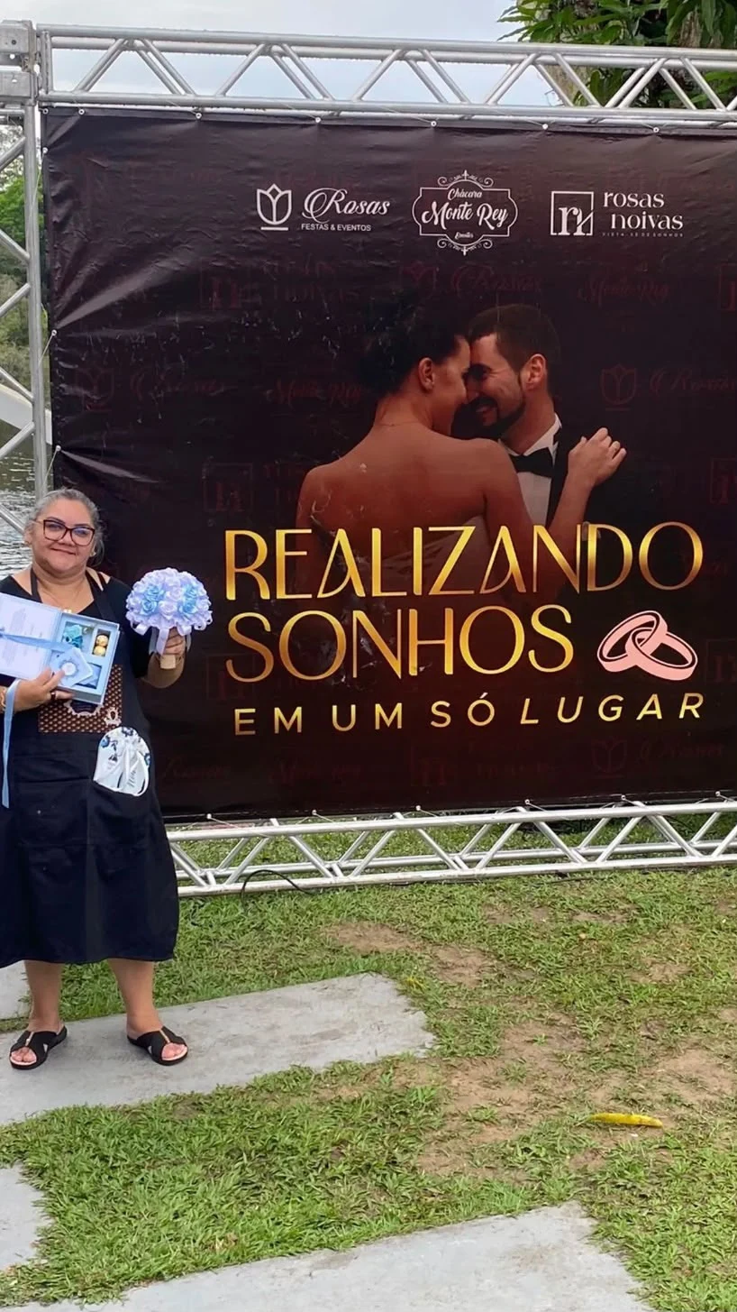 Artesã diante do painel Realizando sonhos, segurando peças personalizadas